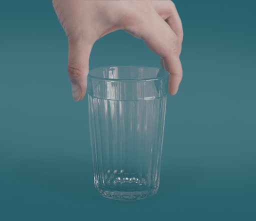 Une main adulte tenant un verre d'eau vide sur un fond bleu uni.