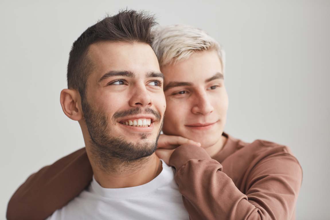 Couple de jeunes hommes regardant au loin vers la droite.
