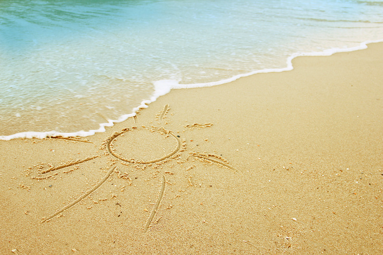 Dessin de soleil gravé dans le sable d'une plage, disparaissant sous l'écume. Dessin de soleil gravé dans le sable d'une plage, disparaissant sous l'écume.