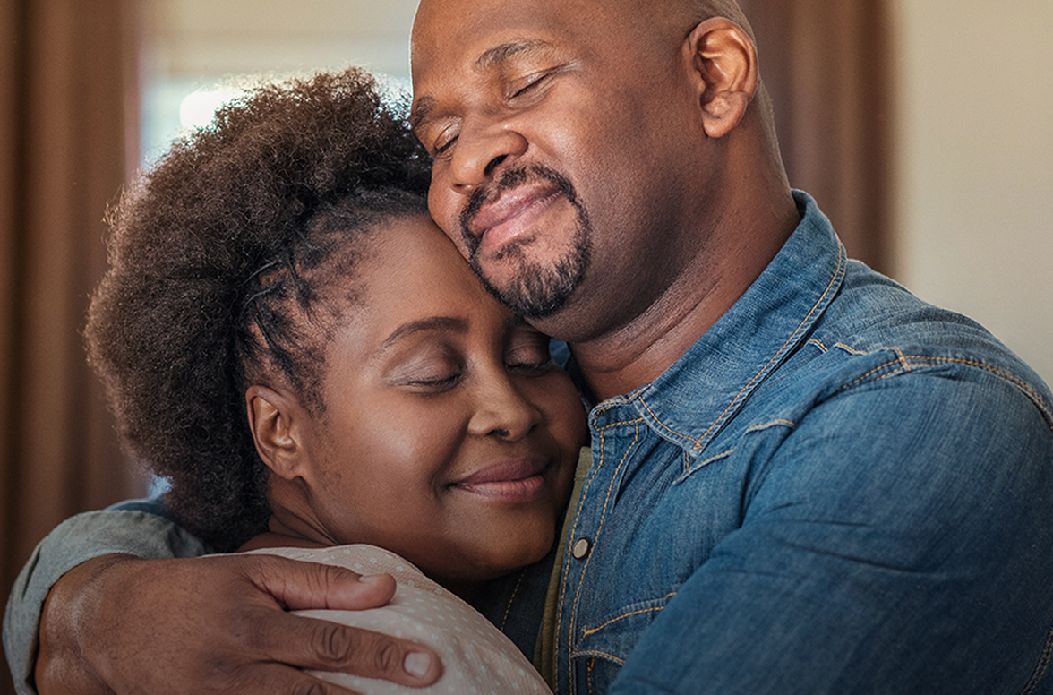 Un couple de personnes noires s'enlaçant tendrement, les yeux fermés avec un sourire heureux. Un couple de personnes noires s'enlaçant tendrement, les yeux fermés avec un sourire heureux.